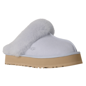 A white UGG slipper with a fluffy trim, featuring a thick beige sole and the UGG logo embossed on the side.