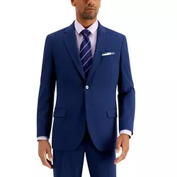 A man wearing a blue two-piece suit with a white dress shirt, a purple striped tie, and a pocket square.