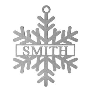 Metal snowflake ornament with the name \“SMITH\“ in the center, featuring a loop for hanging.