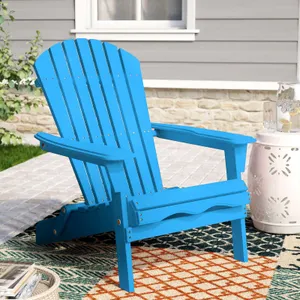 A bright blue Adirondack chair on an outdoor rug, with a small white side table.