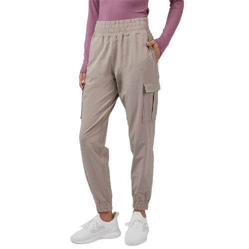 A person is wearing light beige cargo joggers with an elastic waistband and cuffed ankles, paired with a mauve long-sleeve top and white sneakers.