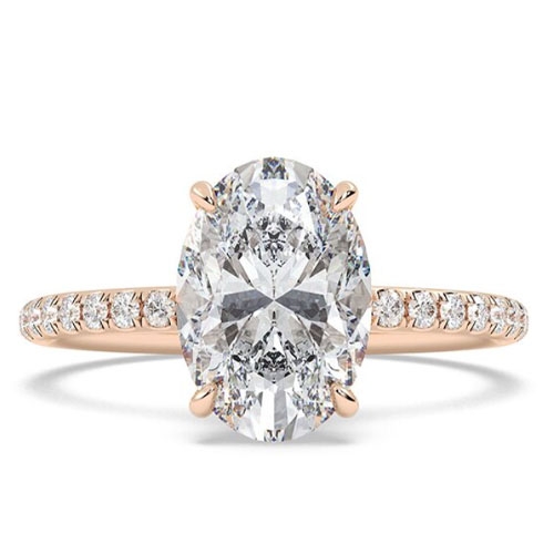 A rose gold engagement ring featuring a large oval diamond set in a four-prong setting, with a band adorned with smaller diamonds.
