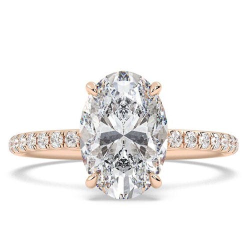 A rose gold engagement ring featuring a large oval diamond set in a four-prong setting, with a band adorned with smaller diamonds.