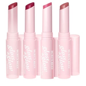 Four Burt's Bees Gloss & Glow lip balms are shown in various shades, each in a pink tube with slanted tips.
