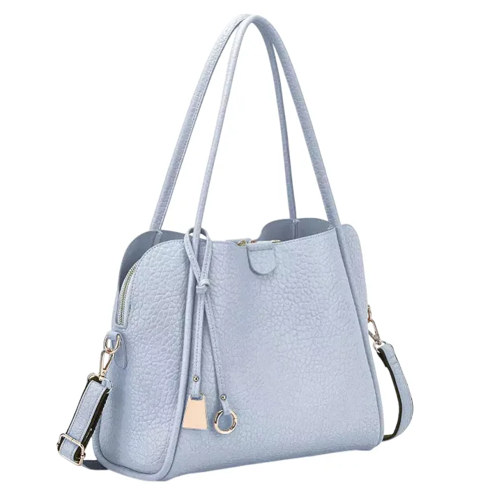 Light blue textured handbag with dual handles, a detachable shoulder strap, and a front knot detail. Features a top zipper closure and gold-tone accents.