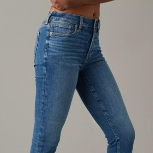 Blue denim jeans on a person, featuring a faded wash and classic pocket detail.