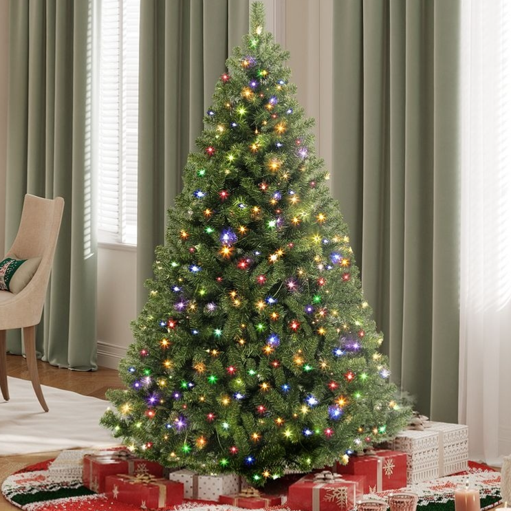 A decorated artificial Christmas tree with multicolored lights is surrounded by wrapped gifts on a festive tree skirt.