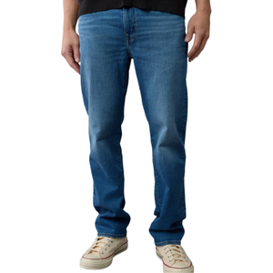 Straight-leg blue jeans paired with off-white sneakers.