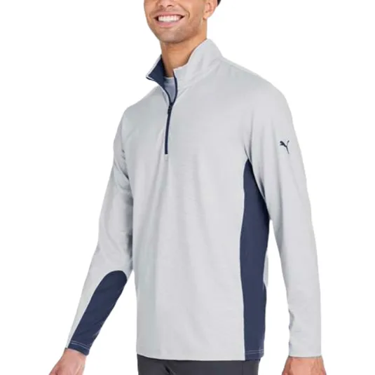 A man is wearing a light gray long-sleeve quarter-zip pullover with navy accents and a small puma logo on the sleeve.