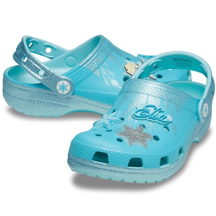 Light blue Crocs featuring a \“Frozen\“ theme with glittery details, snowflakes, and the name \“Elsa\“ on the top.