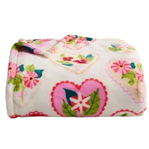 A soft blanket with a floral and heart pattern in pink, green, and blue on a white background.