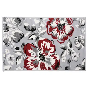 A decorative rug featuring a floral pattern in red, black, and white against a gray background.