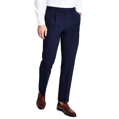 A person wearing dark blue pleated trousers with a white shirt and brown dress shoes.