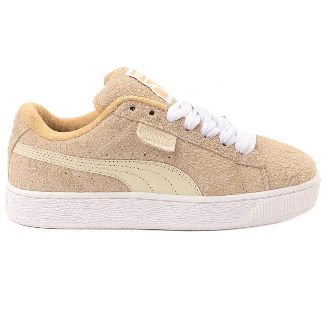 Beige suede sneaker with white sole, featuring a distinctive logo stripe on the side and white laces.