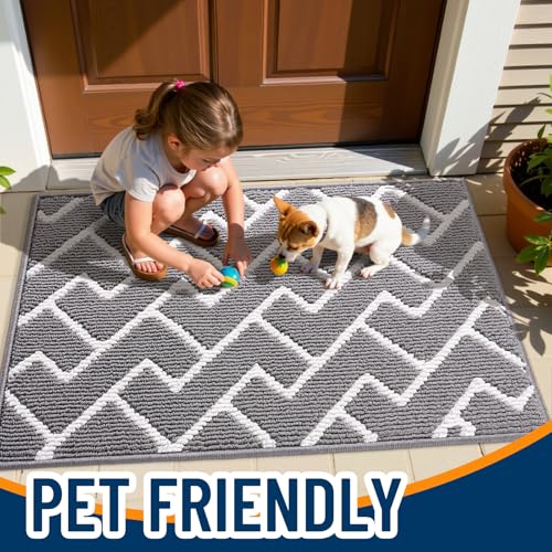 A child and a dog play with toys on a gray and white geometric-patterned doormat labeled \“Pet Friendly\“ positioned at an outdoor entryway.
