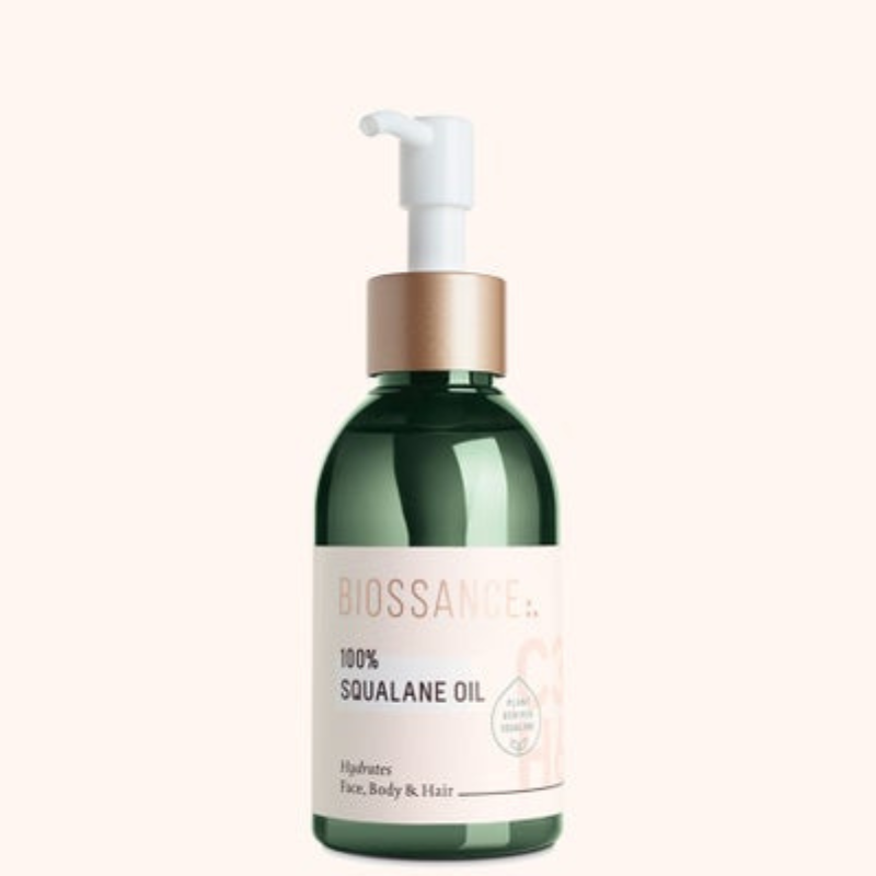 A green bottle with a white pump labeled \“BIOSSANCE: 100% Squalane Oil\“ for hydrating face, body, and hair.