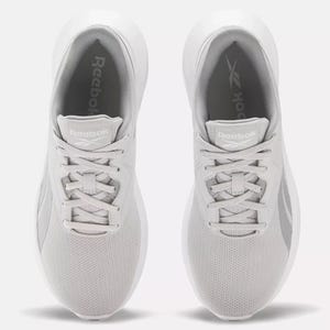 A pair of white sneakers with the logo visible on the tongue and sole.
