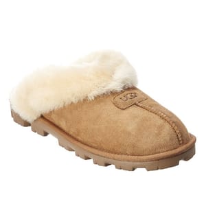 A tan suede slipper with a fluffy white interior lining and a textured sole.