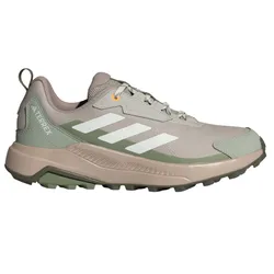 Adidas Terrex hiking shoe with a beige and green color scheme, featuring a rugged sole for improved traction and the signature three stripes in white.