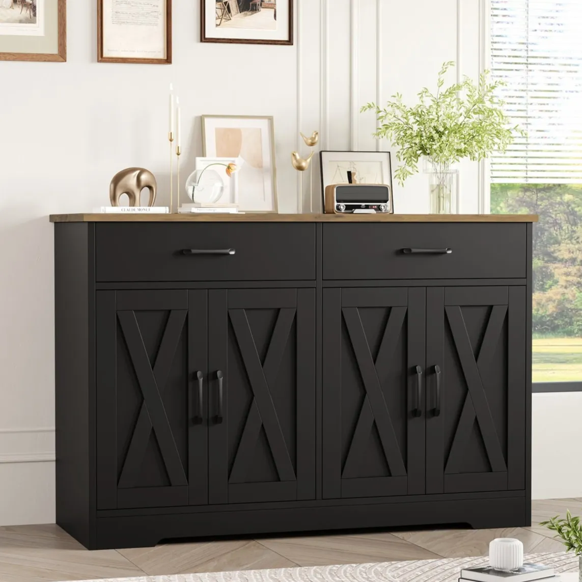 A black sideboard with two drawers and four cabinet doors featuring an X design, topped with decorative items like vases, candles, and artwork.