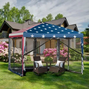 Outdoor canopy with an American flag design featuring stars and stripes, two wicker rocking chairs with cushions inside, set on a grassy lawn with a backdrop of blooming bushes and a house.