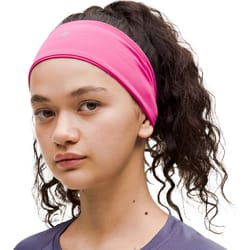 A pink headband with a small circular logo on the front, designed to keep hair in place during workouts.