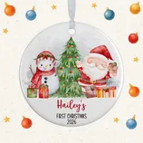 A round ornament featuring Santa, a snowman, and a Christmas tree, with \“Hailey's First Christmas 2026\“ written on it, surrounded by a festive background with stars and baubles.
