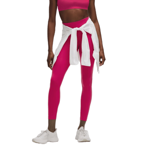 A person is wearing a pink athletic outfit, consisting of a sports bra and leggings, with a white shirt tied around the waist and white sneakers.