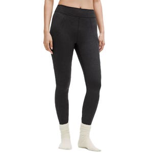 A person is wearing dark gray leggings with an elastic waistband and white socks.