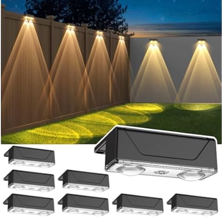 Outdoor LED wall lights are mounted on a fence, emitting warm light to illuminate the surrounding area. Additional units of the same lights are displayed in the foreground.
