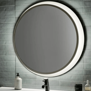 A round, 30-inch backlit LED wall mirror is mounted on a tiled wall above a white sink, featuring modern black faucet and adjacent with lotion and candles.
