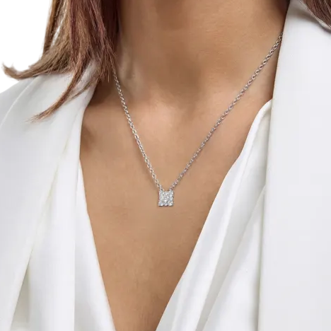 A woman wearing a sterling silver chain necklace with a small square pendant featuring multiple diamonds, set against a white blouse and blazer.