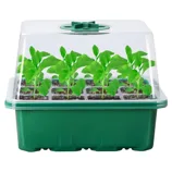 A green seed starter kit with a transparent domed lid containing young green seedlings in individual soil cells.