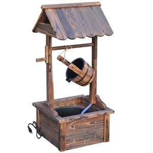 The wishing well fountain is made of rustic wood with a shingled roof and a hanging wooden bucket. It features an electric pump for water circulation and a square base.