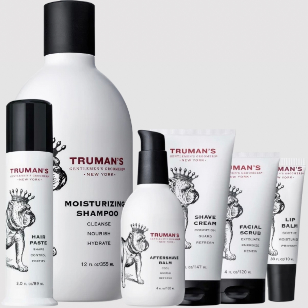 Six grooming products for men, including moisturizing shampoo, hair paste, shave cream, aftershave balm, facial scrub, and lip balm, all branded with Truman's logo.