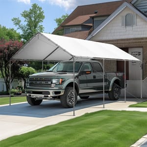 A white canopy shelter is covering a dark gray pickup truck parked on a driveway in front of a house.