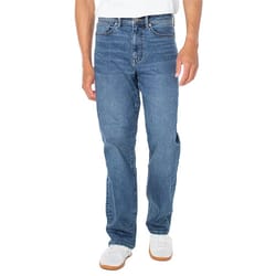 A person wearing blue jeans and white sneakers stands against a plain background.