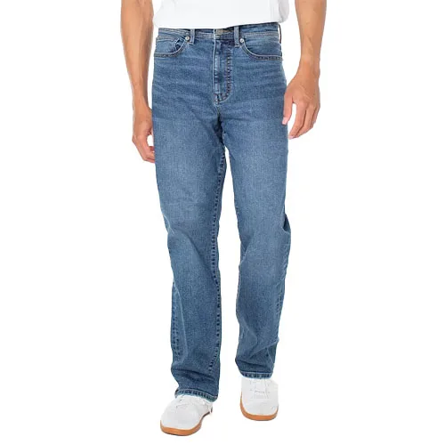 A person wearing blue jeans and white sneakers stands against a plain background.