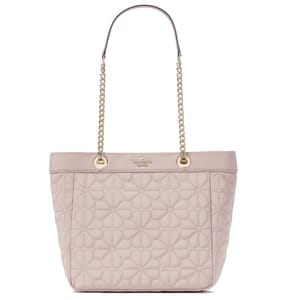 A light pink tote bag with quilted floral patterns, gold chain straps, and a small logo detail at the top center.