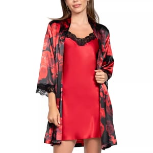A woman is wearing a satin red slip dress with black lace trim, paired with a matching kimono-style robe featuring a red and black floral pattern.