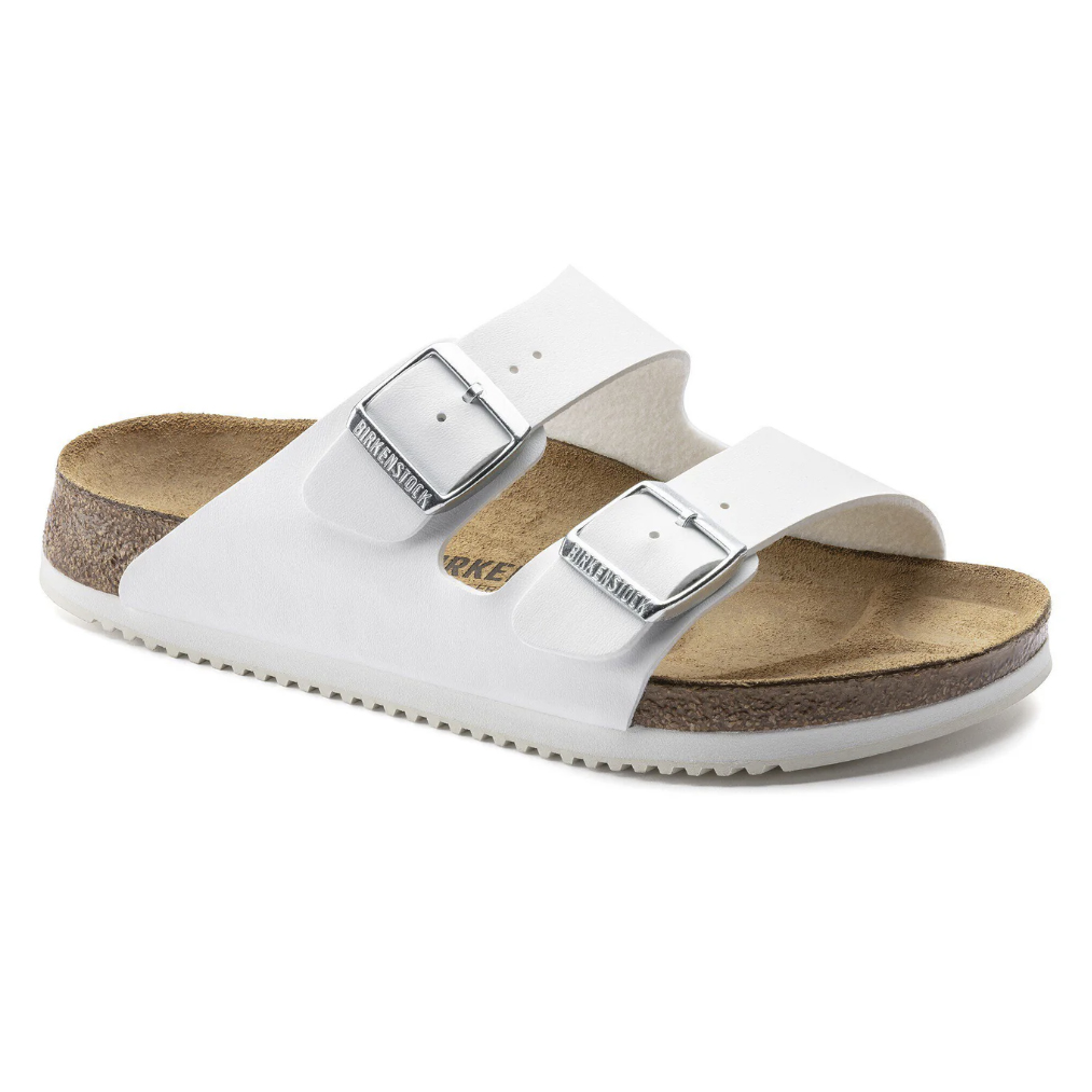 A white sandal with two adjustable straps and buckles, featuring a contoured cork footbed and a rubber sole.