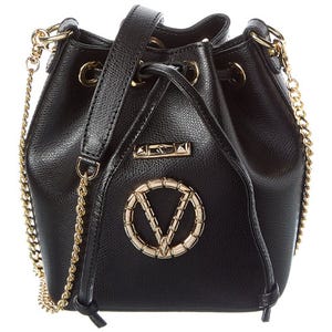 Black bucket bag with gold chain straps and gold circular emblem on front.