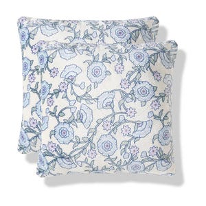Two decorative pillows with a floral pattern featuring blue and purple flowers on a light background.