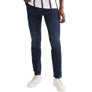 Dark blue slim-fit jeans paired with white sneakers and a striped shirt.