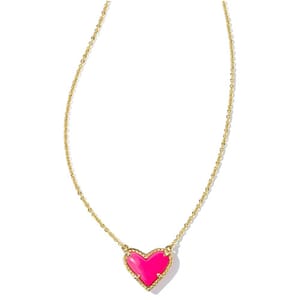 A gold chain necklace featuring a heart-shaped pendant in bright pink, bordered with small crystals.