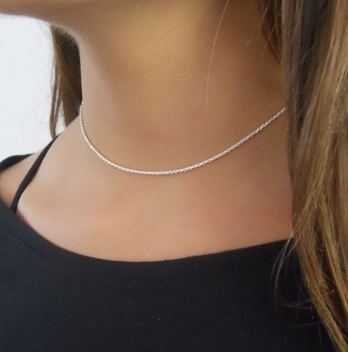 A woman wearing a silver chain necklace.