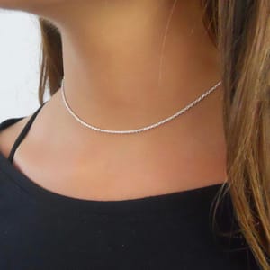 A woman wearing a silver chain necklace.