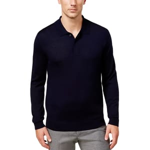 A man wearing a navy long-sleeve polo sweater with a classic collar, buttoned placket, and ribbed cuffs, paired with light gray pants.