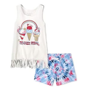 The Americana Summer 2-Piece Outfit Set includes a sleeveless white fringe top with ice cream graphics and \“Summer Vibes\“ text, paired with blue and red tie-dye shorts.