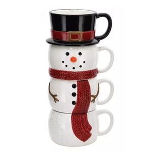 Two stacked ceramic mugs designed to resemble a snowman with a black top hat and a red scarf.